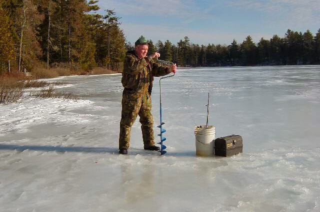 Ψάρεμα σε παγωμένη λίμνη με τρύπα στον πάγο και εξοπλισμό για ακραίες θερμοκρασίες