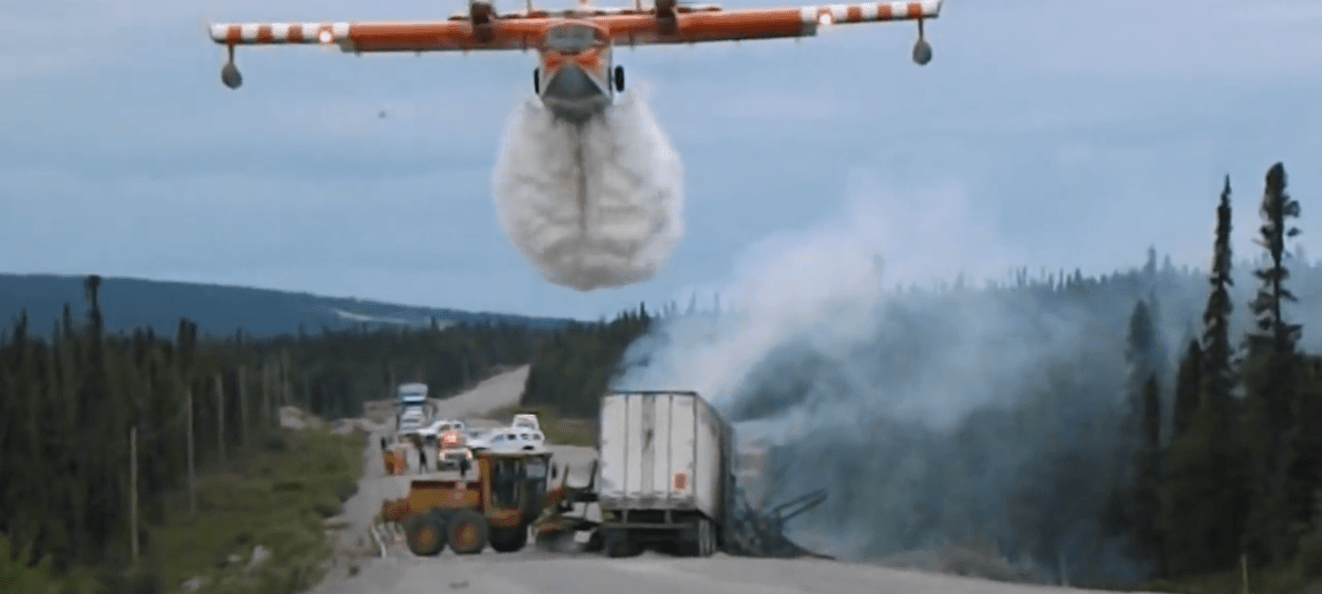 Πυροσβεστικό αεροπλάνο πραγματοποιεί ρίψη νερού πάνω από δασική πυρκαγιά σε απομακρυσμένη περιοχή